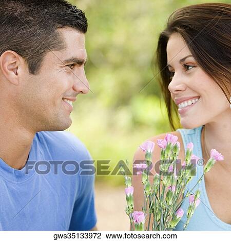 Stock Image - Close-up of a mid adult man and a young woman looking at each other. Fotosearch