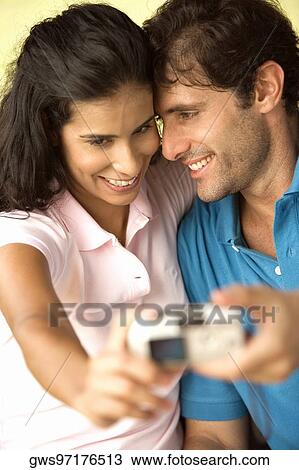 Close-up of a mid adult man and a young woman taking a photograph of themselves View Large Photo Image Stock Image - Close-up of a mid adult man and a young woman taking a photograph of themselves. Fotosearch