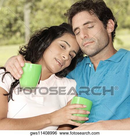 Stock Photograph - Close-up of a mid adult man and a young woman holding coffee cups. Fotosearch