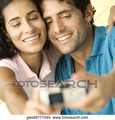 Close-up of a mid adult man and a young woman taking a photograph of themselves View Large Photo Image Stock Photography - Close-up of a mid adult man and a young woman taking a photograph of themselves. Fotosearch