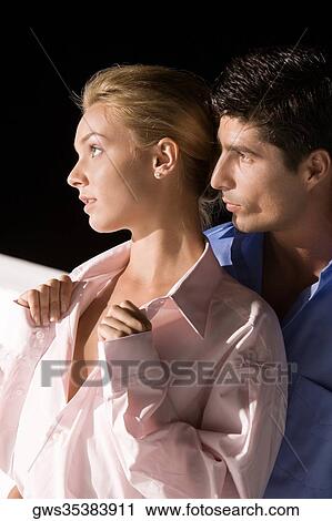 Stock Image - Close-up of a mid adult man embracing a young woman. Fotosearch