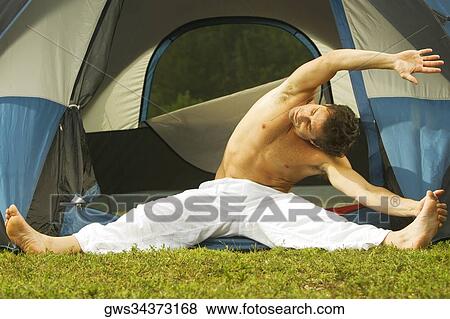 Stock Photo - Close-up of a mid adult man exercising in front of a tent. Fotosearch