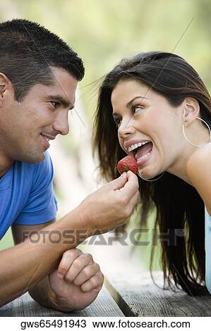 Close-up of a mid adult man feeding a young woman a strawberry View Large Photo Image Stock Image - Close-up of a mid adult man feeding a young woman a strawberry. Fotosearch