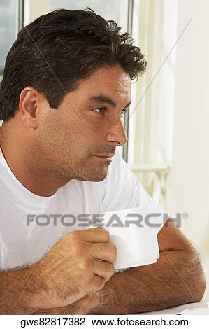 Close-up of a mid adult man holding a mug View Large Photo Image Stock Image - Close-up of a mid adult man holding a mug. Fotosearch
