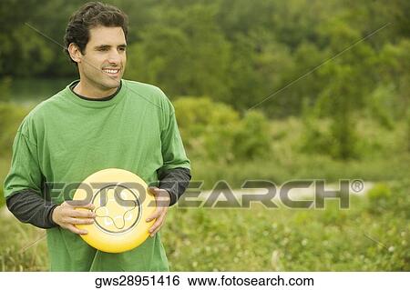 Stock Photograph - Close-up of a mid adult man holding a plastic disc. Fotosearch