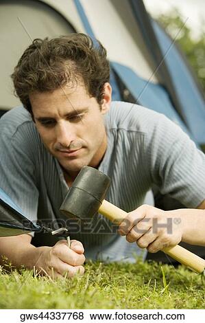 Close-up of a mid adult man pitching a tent View Large Photo Image Stock Photo - Close-up of a mid adult man pitching a tent. Fotosearch