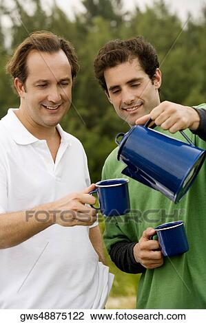 Close-up of a mid adult man pouring tea into a mug View Large Photo Image Stock Image - Close-up of a mid adult man pouring tea into a mug. Fotosearch