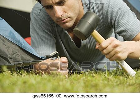 Close-up of a mid adult man putting up a tent View Large Photo Image Stock Image - Close-up of a mid adult man putting up a tent. Fotosearch