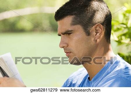 Close-up of a mid adult man reading a book View Large Photo Image Stock Photo - Close-up of a mid adult man reading a book. Fotosearch