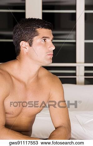 Close-up of a mid adult man sitting on the bed View Large Photo Image Stock Image - Close-up of a mid adult man sitting on the bed. Fotosearch