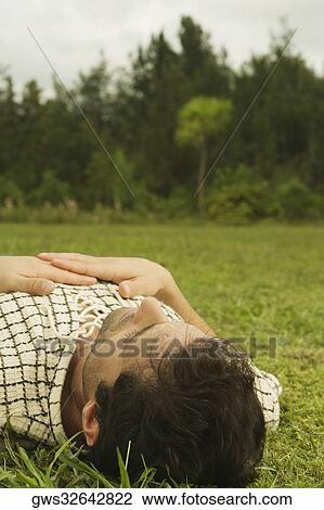 Close-up of a mid adult man sleeping on the grass View Large Photo Image Stock Image - Close-up of a mid adult man sleeping on the grass. Fotosearch