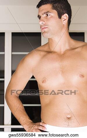 Picture - Close-up of a mid adult man standing with his hand on his hip. Fotosearch