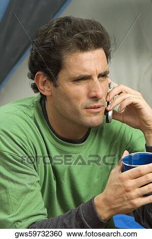 Stock Image - Close-up of a mid adult man talking on a mobile phone. Fotosearch