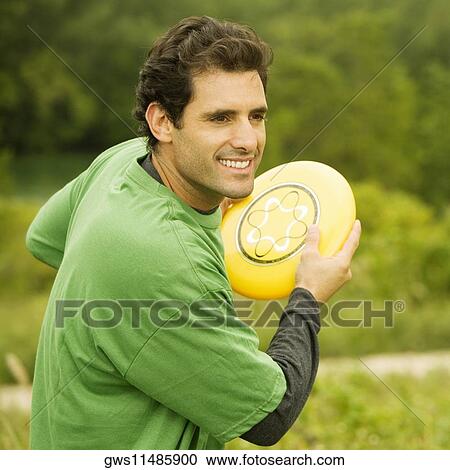 Close-up of a mid adult man throwing a plastic disc View Large Photo Image Stock Image - Close-up of a mid adult man throwing a plastic disc. Fotosearch