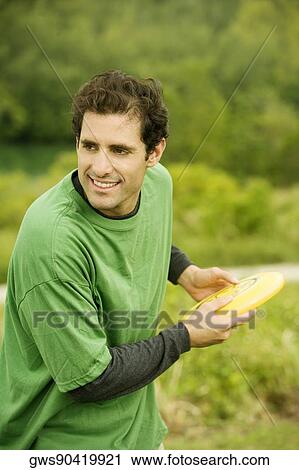 Close-up of a mid adult man throwing a plastic disc View Large Photo Image Stock Image - Close-up of a mid adult man throwing a plastic disc. Fotosearch