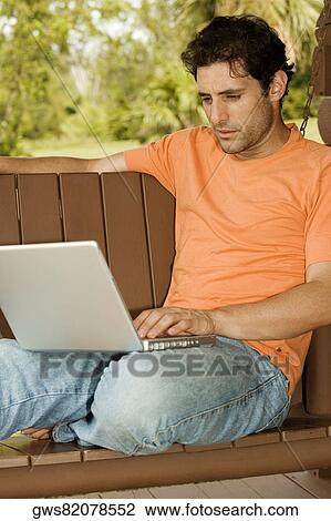 Close-up of a mid adult man using a laptop View Large Photo Image Stock Image - Close-up of a mid adult man using a laptop. Fotosearch