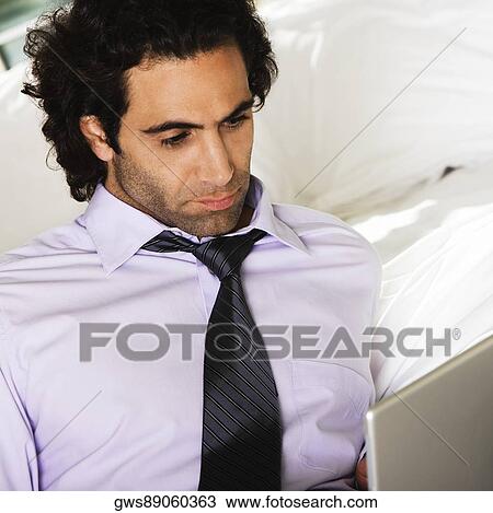 Close-up of a mid adult man using a laptop View Large Photo Image Stock Image - Close-up of a mid adult man using a laptop. Fotosearch