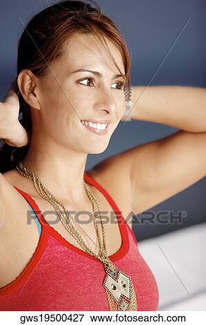 Close-up of a mid adult woman smiling with her hands behind her head View Large Photo Image Stock Photo - Close-up of a mid adult woman smiling with her hands behind her head. Fotosearch