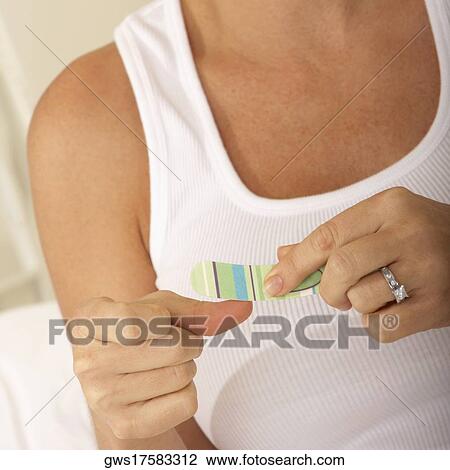 Close-up of a mid adult woman using a nail file View Large Photo Image Stock Image - Close-up of a mid adult woman using a nail file. Fotosearch