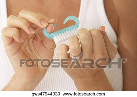 Close-up of a mid adult woman using a nail brush View Large Photo Image Stock Image - Close-up of a mid adult woman using a nail brush. Fotosearch
