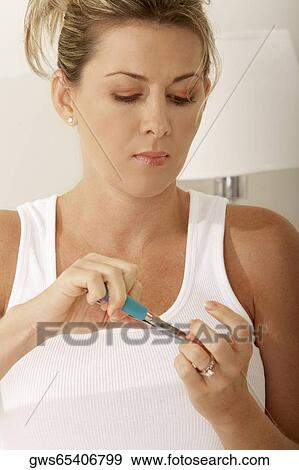 Close-up of a mid adult woman using a nail clipper View Large Photo Image Stock Photo - Close-up of a mid adult woman using a nail clipper. Fotosearch