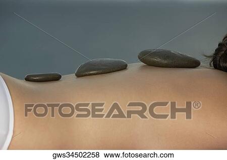 Close-up of a person's back getting hot stone therapy View Large Photo Image Stock Photo - Close-up of a person's back getting hot stone therapy. Fotosearch