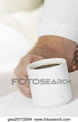 Close-up of a person's hand holding a mug View Large Photo Image Picture - Close-up of a person's hand holding a mug. Fotosearch