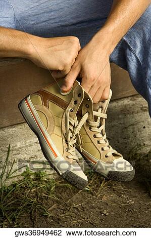 Close-up of a person's hand holding a pair of canvas shoe View Large Photo Image Stock Image - Close-up of a person's hand holding a pair of canvas shoe. Fotosearch