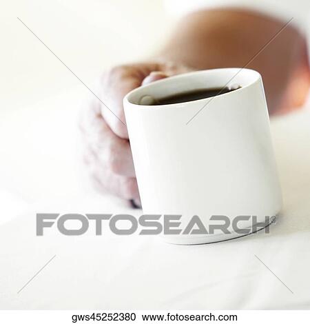 Close-up of a person's hand holding a cup of coffee View Large Photo Image Stock Image - Close-up of a person's hand holding a cup of coffee. Fotosearch