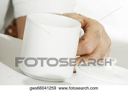 Close-up of a person's hand holding a mug View Large Photo Image Stock Photo - Close-up of a person's hand holding a mug. Fotosearch