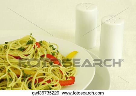 Close-up of a plate of noodles near a salt and pepper shaker View Large Photo Image Stock Photo - Close-up of a plate of noodles near a salt and pepper shaker. Fotosearch