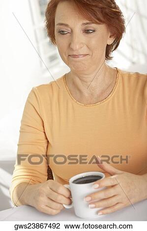 Close-up of a senior woman holding a cup of black coffee View Large Photo Image Stock Image - Close-up of a senior woman holding a cup of black coffee. Fotosearch