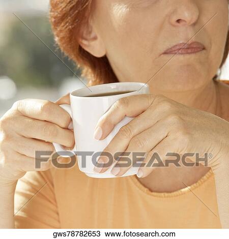 Close-up of a senior woman holding a coffee cup View Large Photo Image Stock Image - Close-up of a senior woman holding a coffee cup. Fotosearch