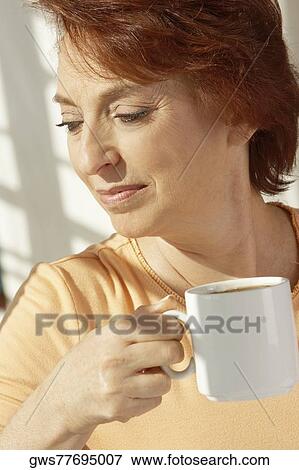 Stock Photo - Close-up of a senior woman holding a cup of coffee. Fotosearch