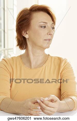 Close-up of a senior woman seated at the table looking sideways View Large Photo Image Stock Image - Close-up of a senior woman seated at the table looking sideways. Fotosearch