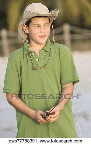 Stock Image - Close-up of a teenage boy holding a fishing rod. Fotosearch