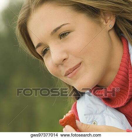 Close-up of a teenage girl eating a strawberry View Large Photo Image Picture - Close-up of a teenage girl eating a strawberry. Fotosearch