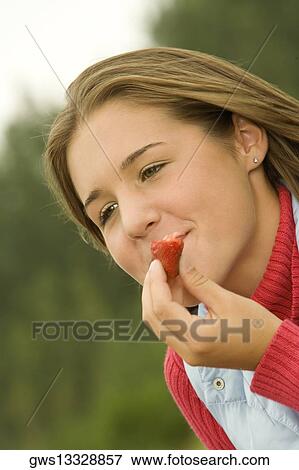 Close-up of a teenage girl eating a strawberry View Large Photo Image Stock Photo - Close-up of a teenage girl eating a strawberry. Fotosearch