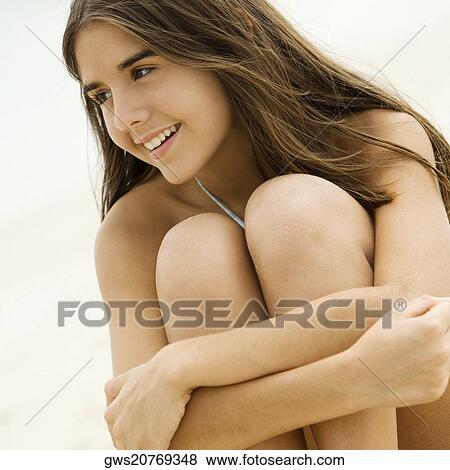 Close-up of a teenage girl sitting on the beach smiling View Large Photo Image Stock Photo - Close-up of a teenage girl sitting on the beach smiling. Fotosearch