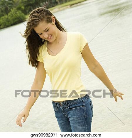 Stock Image - Close-up of a teenage girl walking on the beach looking down. Fotosearch