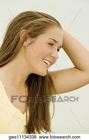 Stock Photo - Close-up of a teenage girl with her hand in her hair. Fotosearch