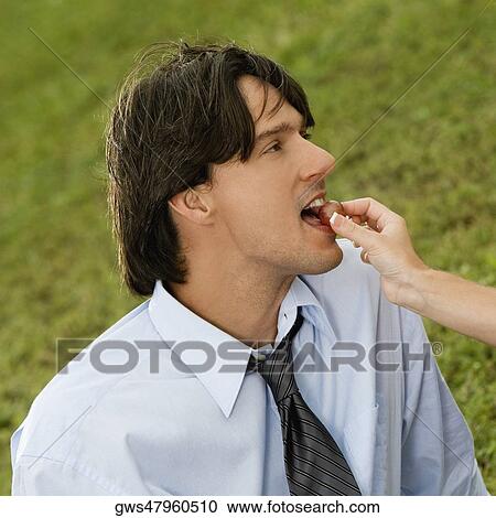 Close-up of a woman feeding a cherry to a businessman View Large Photo Image Stock Image - Close-up of a woman feeding a cherry to a businessman. Fotosearch