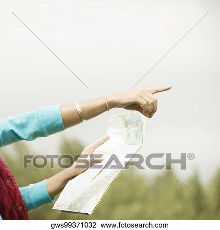 Close-up of a woman's hand holding a map pointing forward View Large Photo Image Stock Image - Close-up of a woman's hand holding a map pointing forward. Fotosearch