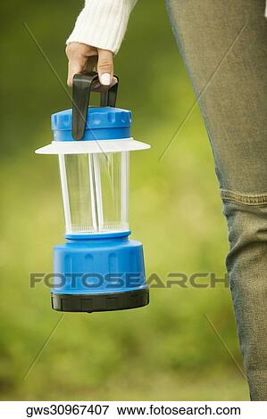 Close-up of a woman's hand holding a lamp View Large Photo Image Stock Photo - Close-up of a woman's hand holding a lamp. Fotosearch