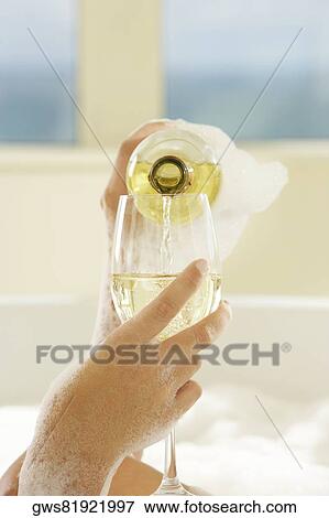 Close-up of a woman's hand pouring champagne in champagne flute View Large Photo Image Stock Photo - Close-up of a woman's hand pouring champagne in champagne flute. Fotosearch