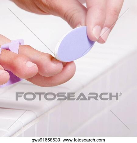 Close-up of a woman's hand shaping her toenail with a nail file View Large Photo Image Stock Image - Close-up of a woman's hand shaping her toenail with a nail file. Fotosearch