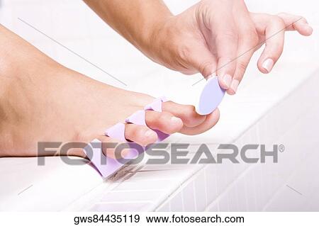 Close-up of a woman's hand shaping her toenail with a nail file View Large Photo Image Stock Photo - Close-up of a woman's hand shaping her toenail with a nail file. Fotosearch