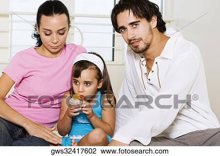 Close-up of a young couple and their daughter eating a pastry View Large Photo Image Stock Image - Close-up of a young couple and their daughter eating a pastry. Fotosearch