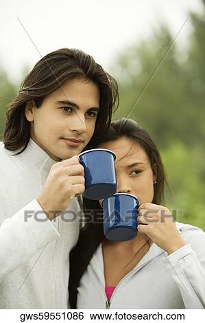 Close-up of a young couple drinking coffee View Large Photo Image Stock Photograph - Close-up of a young couple drinking coffee. Fotosearch