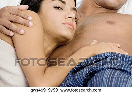 Close-up of a young couple lying on the bed View Large Photo Image Stock Photo - Close-up of a young couple lying on the bed. Fotosearch